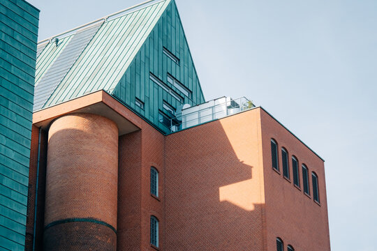 Modern Brick and Copper Building with Rooftop Terrace in Daylight