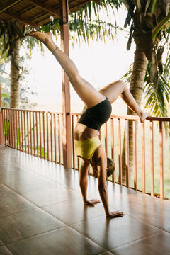 Woman Performing Handstand in Tropical Veranda