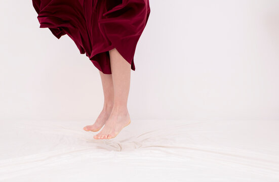 Surreal female legs jumping on bed