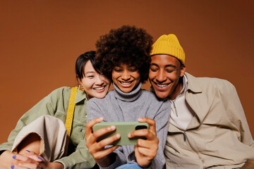 Three friends watching funny video on smartphone