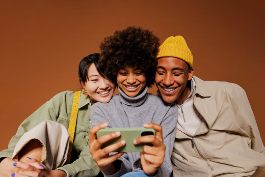Three friends watching funny video on smartphone