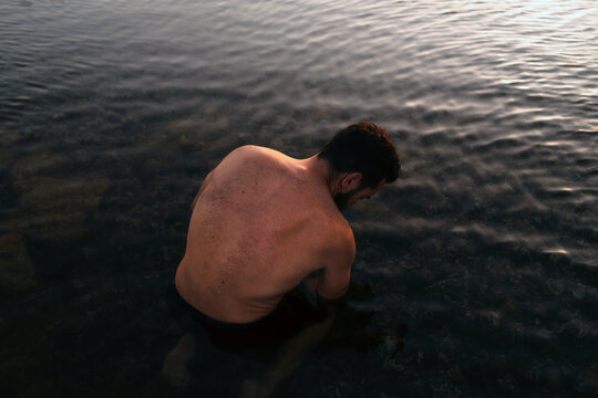 Shirtless muscular man in water