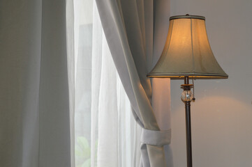 a lamp stand against a gray window curtain interior in a hotel