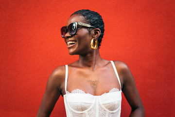 Black woman smiling in front of a bold red background