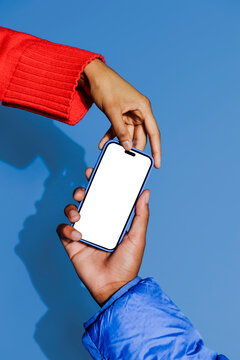 Two people holding smartphone with blank screen on blue background