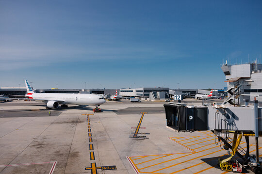Modern airport in New York with parked airplanes and boarding gates.