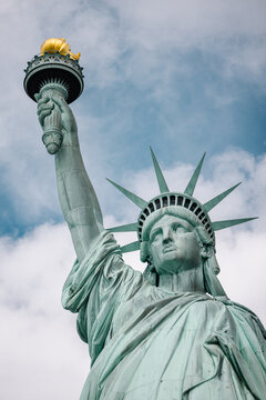 Statue of Liberty close-up against a cloudy sky in New York