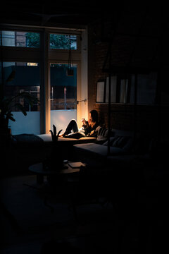 Tourist enjoying a relaxing night lying down in bed using a smartphone
