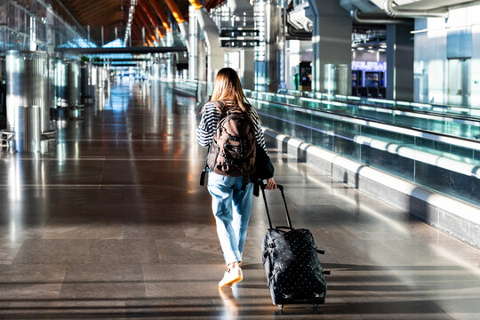 Female vacationer pulling her luggage through New York's airport