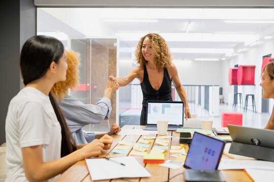 Coworkers shaking hands during a team meeting