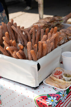 Churros at a street vendor stand with a colorful tablecloth 