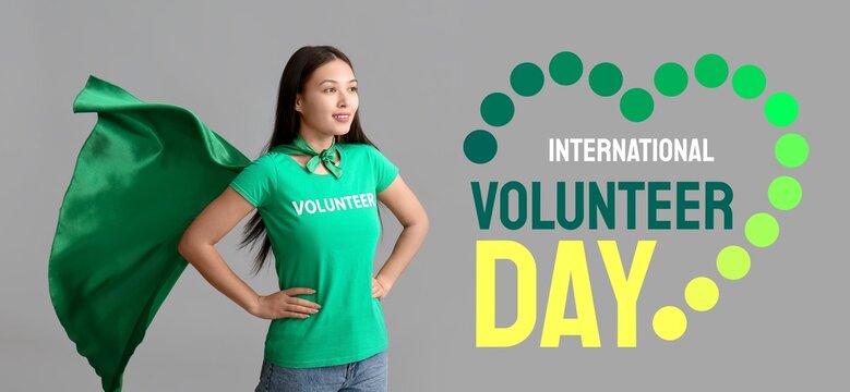 Female volunteer in superhero cape on grey background. Banner for International Volunteer Day - Powered by Adobe