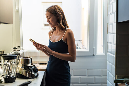 Female Cook Follows a Healthy Recipe on Smartphone 