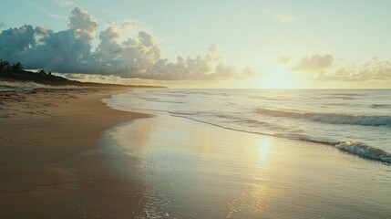 Fototapeta premium A quiet, serene beach at sunrise with soft morning light illuminating the coastline and wet sand