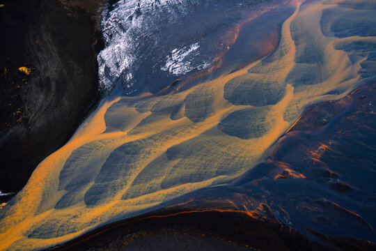 Fototapeta Aerial view of abstract orange river in Iceland with black sand