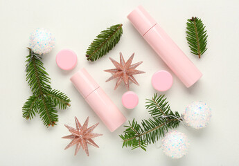 Beautiful composition with bottles, jars of cosmetic products and Christmas decorations on light background
