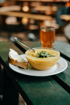 Vegetable cream soup in a bowl with cozy outdoor background
