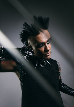 Edgy man in punk rock attire with intense makeup and mohawk hairstyle