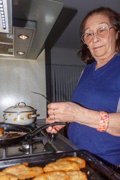 Grandmother preparing the delicious chicken milanesas