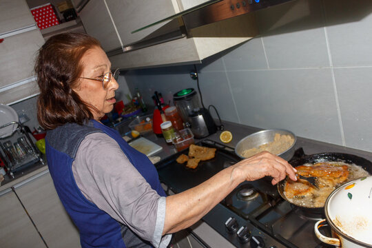 Grandmother cooking crispy milanesas in the kitchen