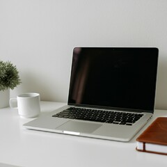 Modern workspace with a laptop, coffee, and notebook on a clean desk