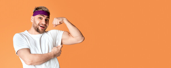 Funny millennial guy shows biceps, on yellow background,