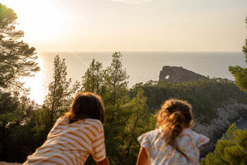 Kids looking. out the beautiful view on a seaside walk in Mallorca.