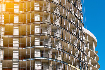 Insulation and Installation of glass curtain wall. Building under construction. Structural glass...