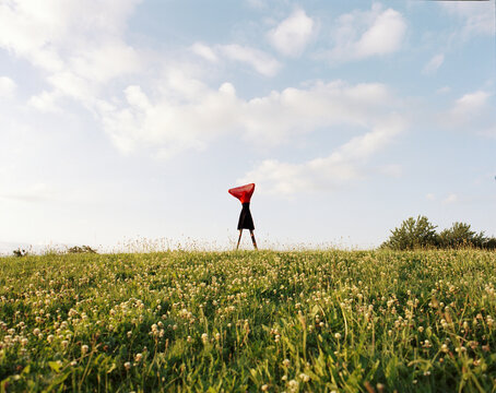 Person Standing in Field with Red Cloth on a Sunny Day