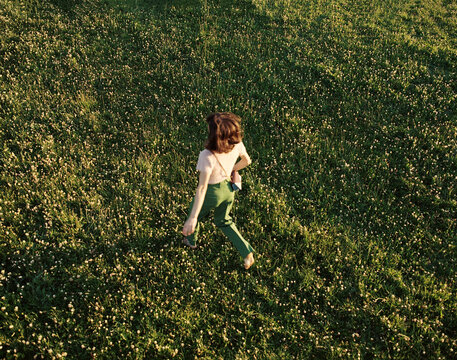Woman  Running Freely in a Lush Green Field