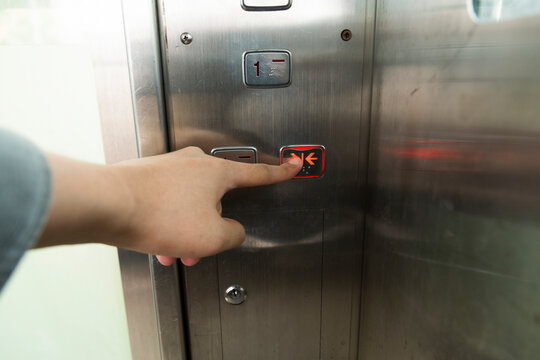 A hand pressing elevator button
