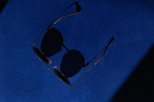 Stylish sunglasses on a vibrant blue armchair background.  