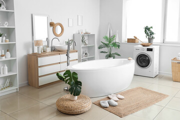 Interior of bathroom with bathtub, washing machine and wicker mat