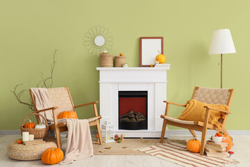 Naklejka premium Interior of room with fireplace, pumpkins and armchairs