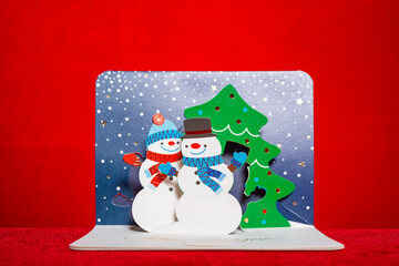 3D gift card with Christmas decorations snowmen and fir-trees