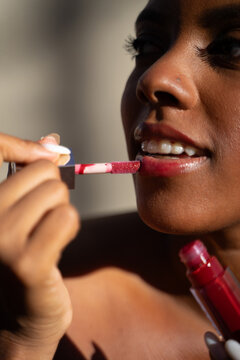 Dominican Woman Applying Lip Gloss