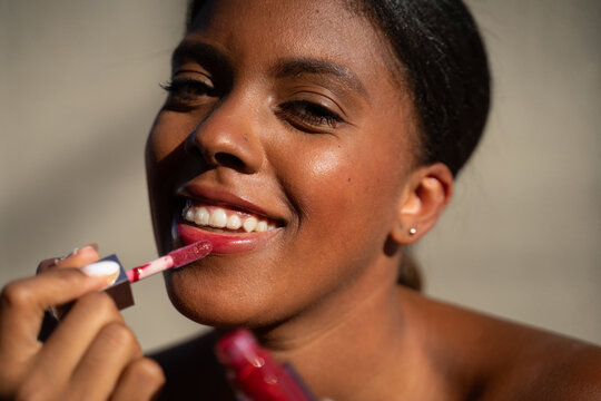 Dominican Woman Applying Lip Gloss