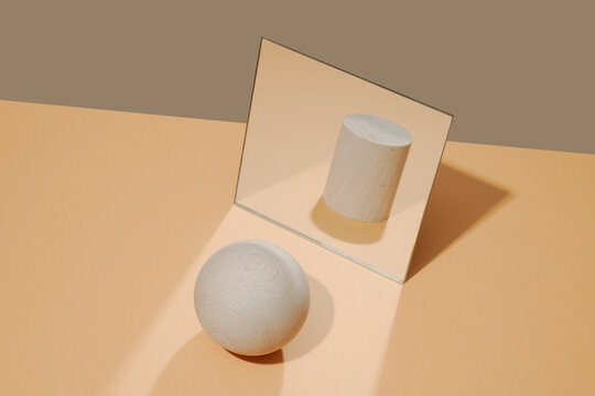 ball in front of a mirror reflects the image of a cylinder