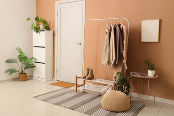 Interior of hallway with clothes rack, drawers and door