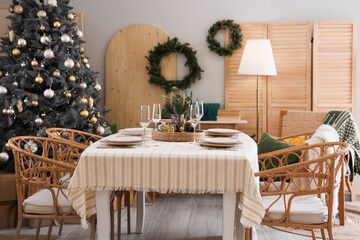 Interior of dining room with table, Christmas tree and wreaths