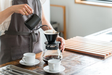 キッチン・カフェでコーヒーをいれる女性
