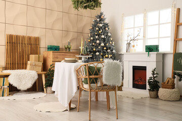 Interior of dining room with table, fireplace and Christmas tree