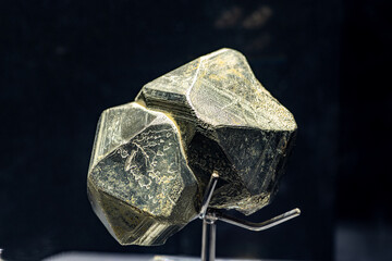A close up of iron pyrite mineral isolated on black background.
