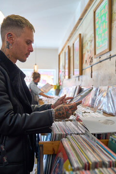 Young guy browsing vinyl in a cozy record store