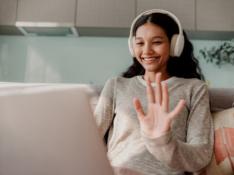 Smiling Woman Using Laptop for Video Call with Headphones