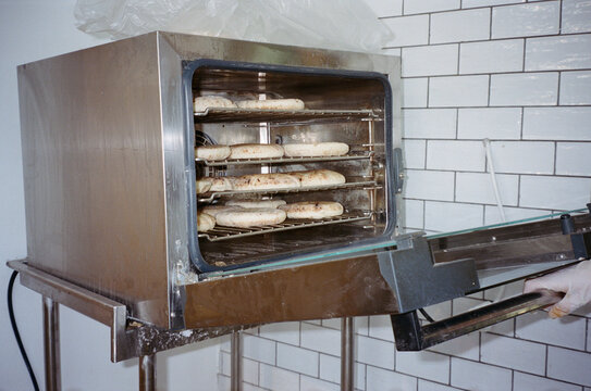 Gloved Hand Checking Fresh Pitas In A Commercial Oven