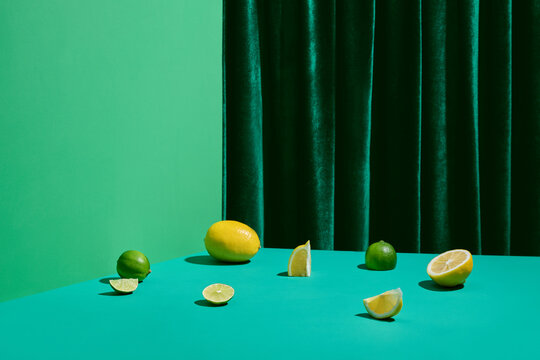 Lemons and Limes Arranged on a Vibrant Green Table