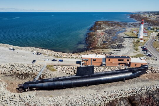 The HMCS Onondaga (S73) Submarine on display,. Behind is the Lieu historique national du phare de Pointe-au-P&egrave;re, Lighthouse. Rimouski, Quebec, Canada.