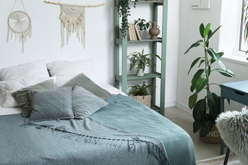 Interior of bedroom with cozy bed and houseplants