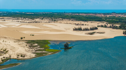 Aerial view of Bau Trang lake (a beautiful landscape, raw of automobiles with blue sky in desert, beautiful landscape of white sand dunes), the popular tourist attraction place in Mui Ne, Vietnam.
